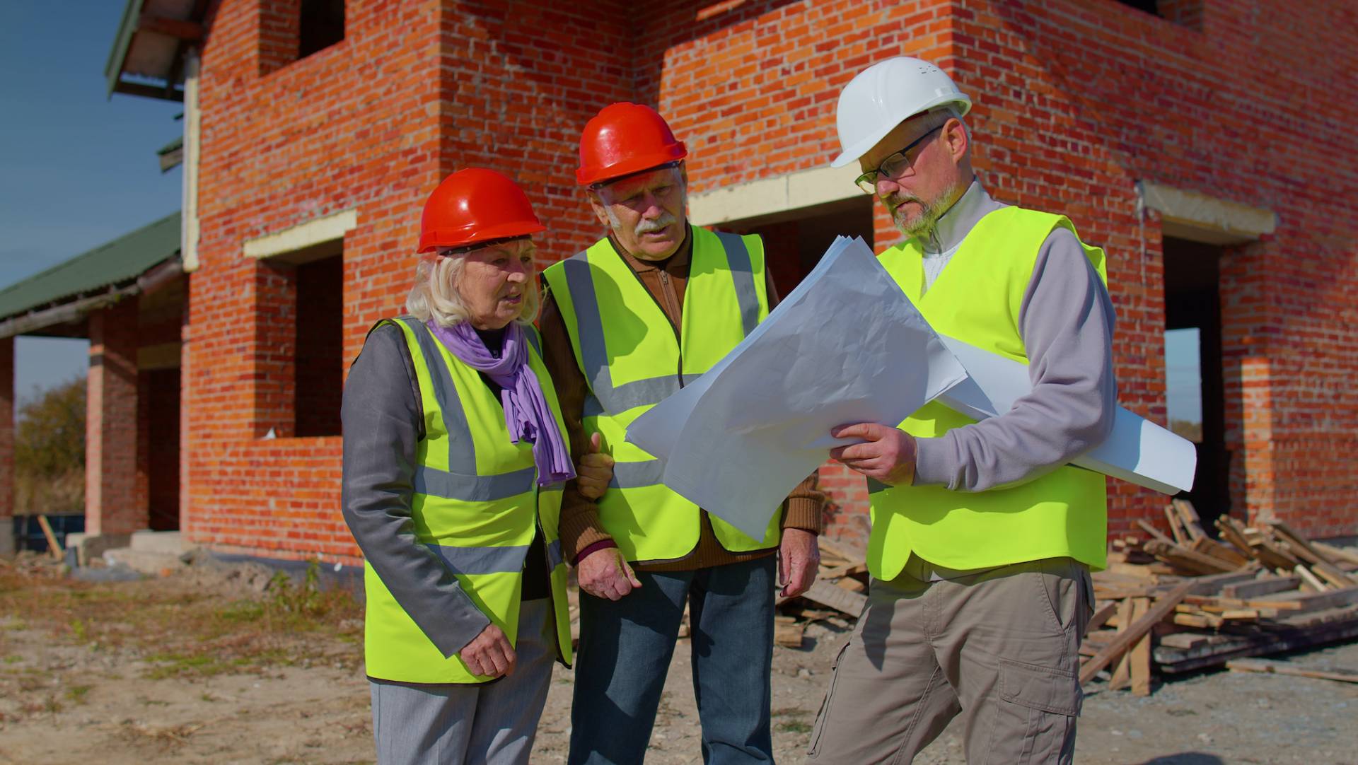 Construction workers in front of a brick building