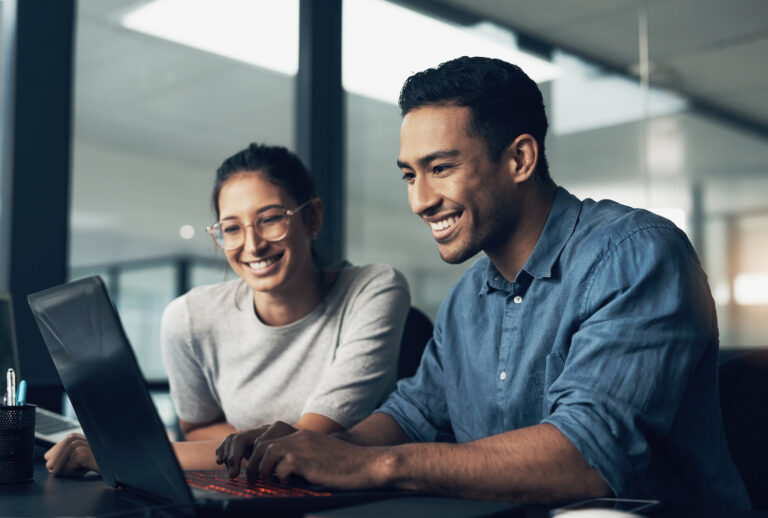 Shot of two young workers using a laptop in a modern office