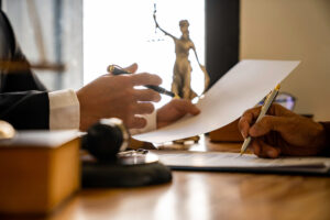 A view of two peoples hands both holding a pen going over a contract